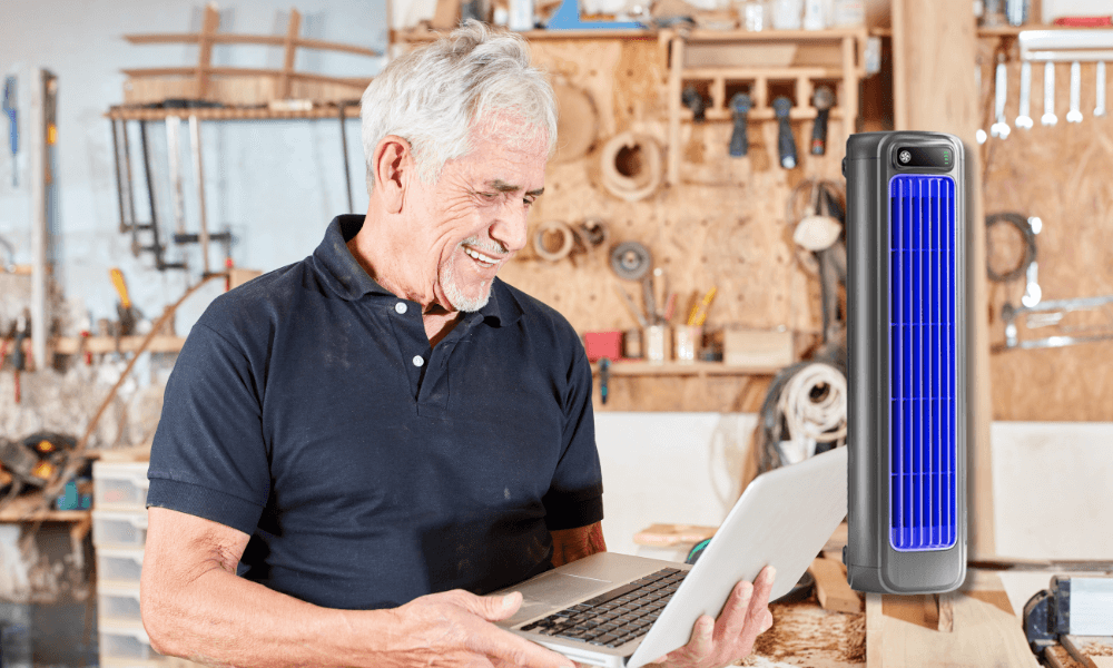 Older man using laptop with BrizaAC device on desk